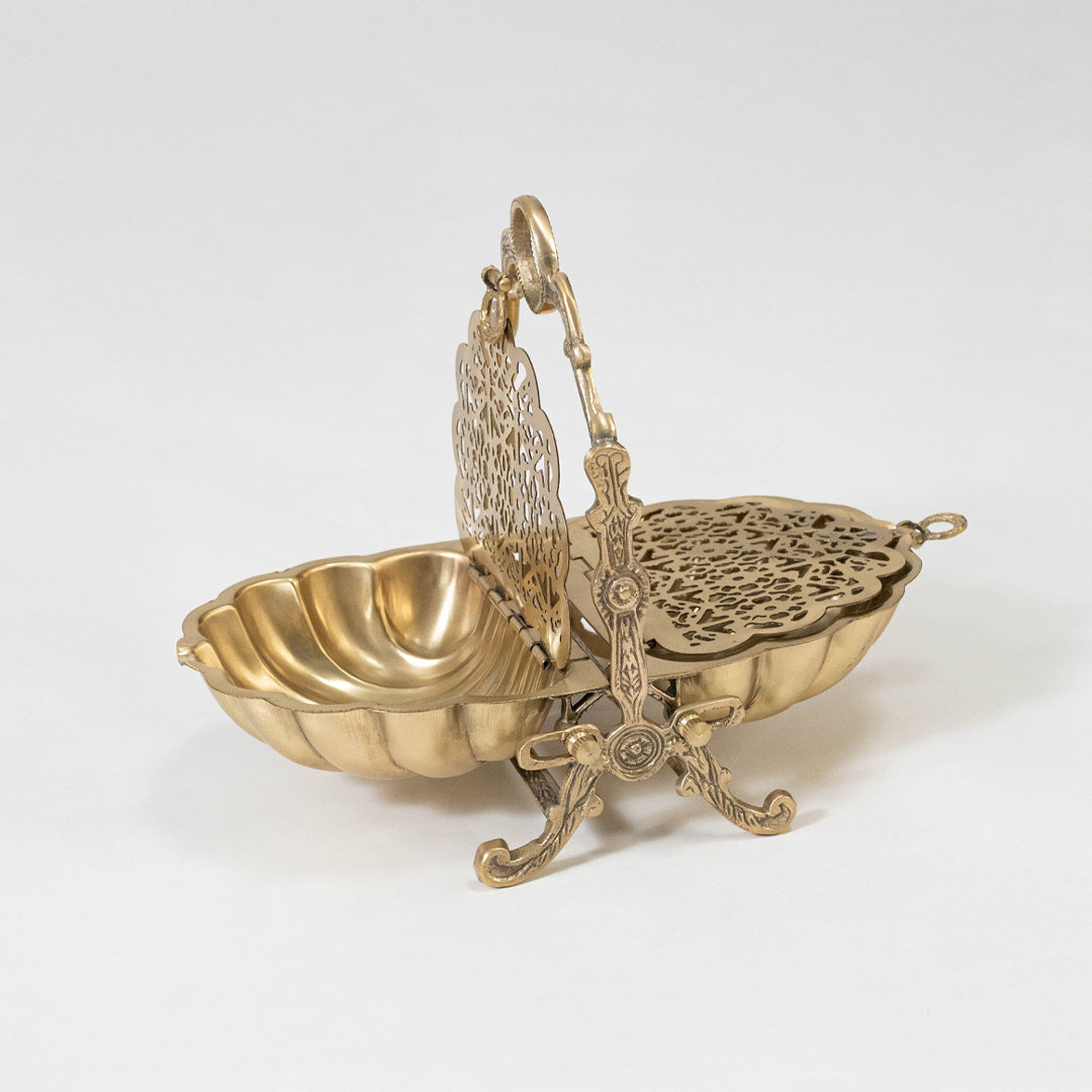 Decorative metal basket in gold finish with handle for dining table or serving decor accessory placement white background.