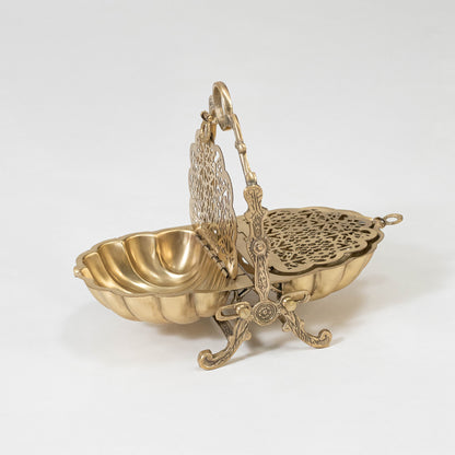 Decorative metal basket in gold finish with handle for dining table or serving decor accessory placement white background.