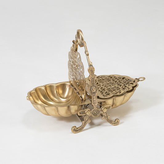 Decorative metal basket in gold finish with handle for dining table or serving decor accessory placement white background.