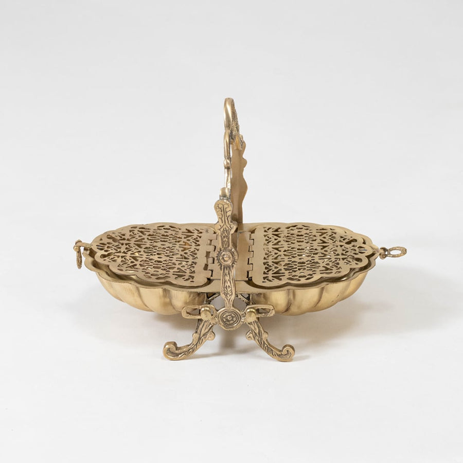 Studio shot of the ornate brass biscuit warmer with jali patterns isolated on a white background for a dramatic and elegant presentation.