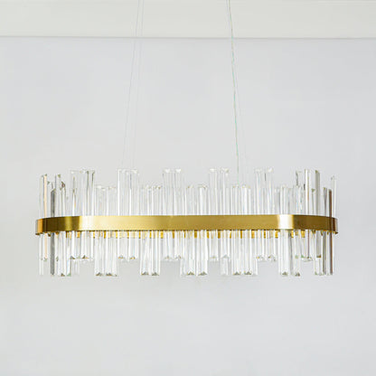 Contemporary gold metal wall sconce with clear glass rod design fixed on minimal white wall background ideal for modern decorative lighting setup.