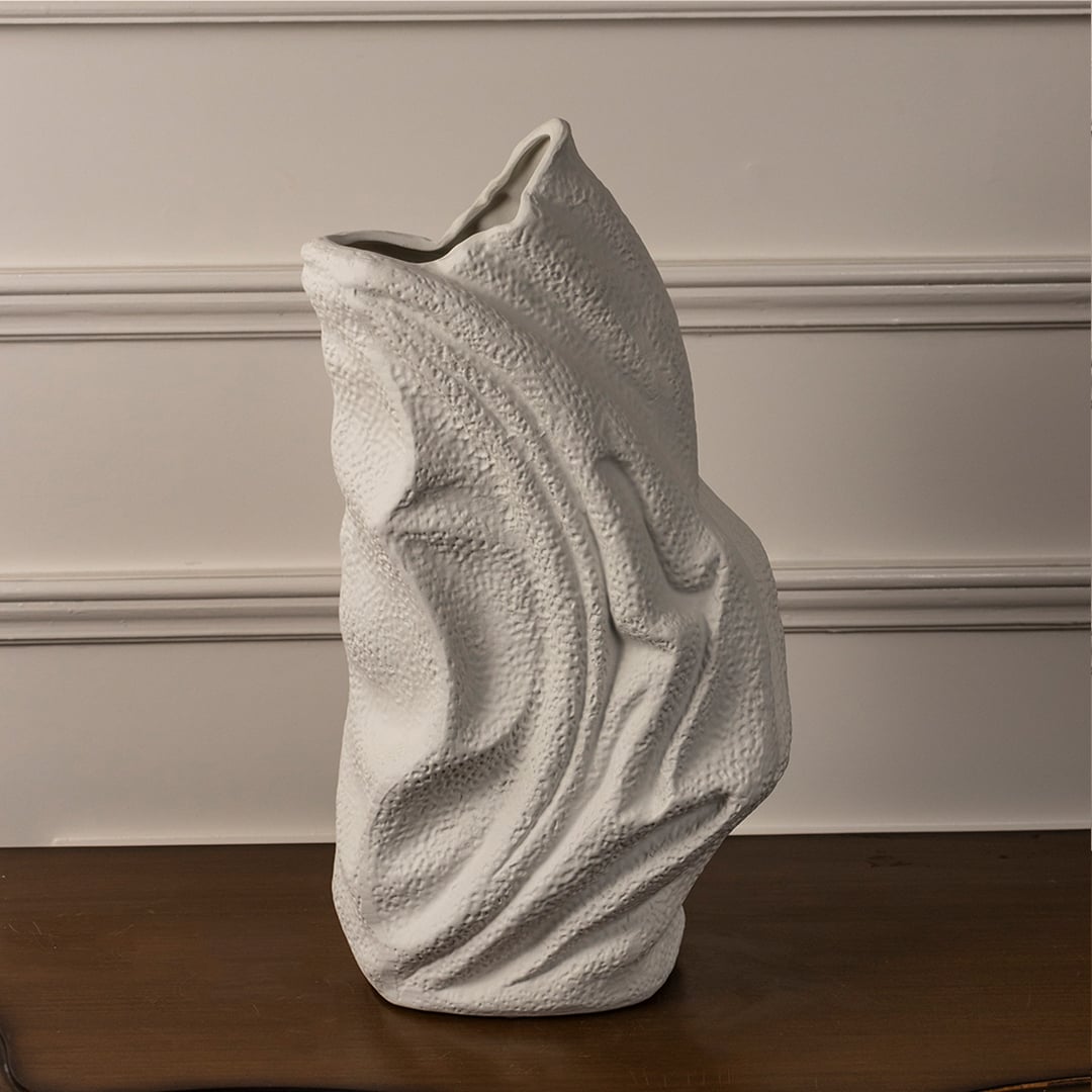 White ceramic textured vase with artistic wavy surface placed on white background for elegant modern home decor.