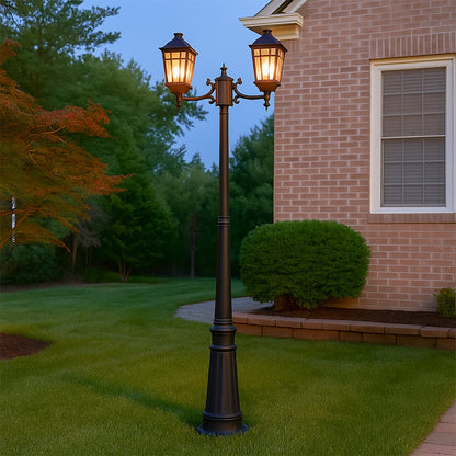 Traditional black metal dual head post lamp standing tall in outdoor garden setting creating vintage street light ambiance.
