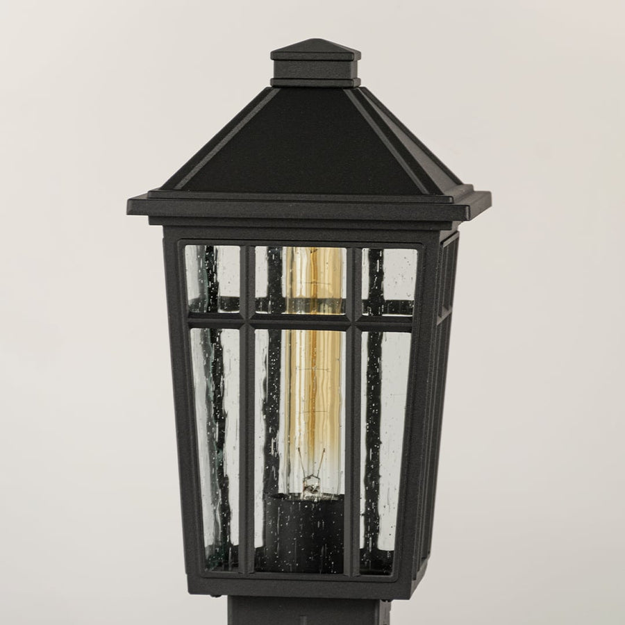 Black outdoor lantern Closeup seeded glass Light On showing the warm ambient glow and decorative pebbled glass panels detail.
