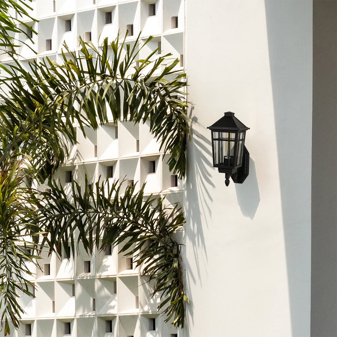 A classic black clear glass outdoor lantern mounted on a bright white exterior wall enhancing architectural design and adding stylish outdoor lighting appeal.