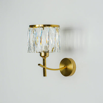 Gold wall light with crystal glass shade mounted on neutral wall background ideal for luxury bedroom or living room decor lighting.