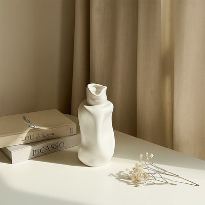 Elegant white ceramic sculptural vase styled in a soft minimal setting adding modern artistic decor to contemporary interiors.