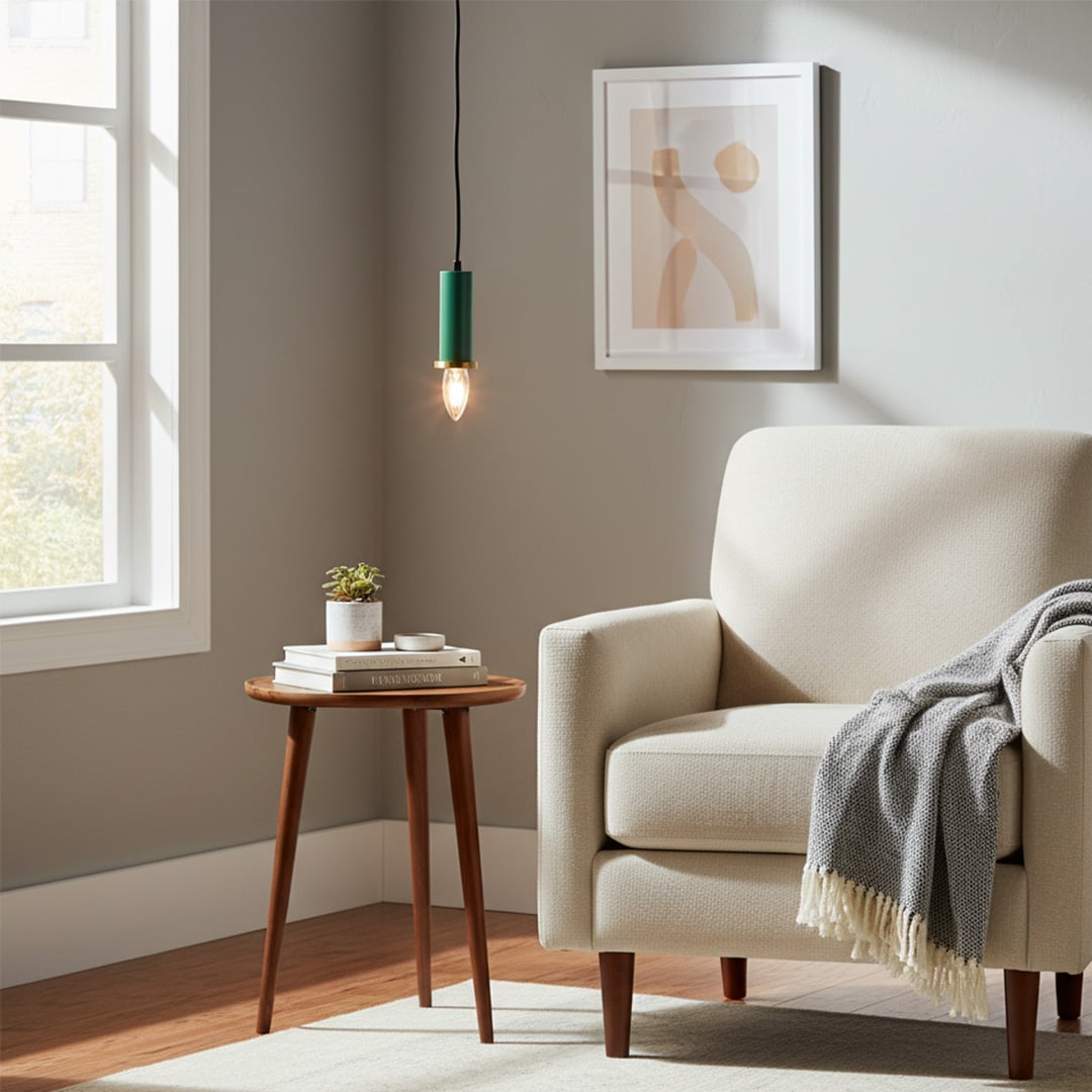 Green metal pendant light hanging near an accent chair creating warm ambient lighting in a modern living room corner space.
