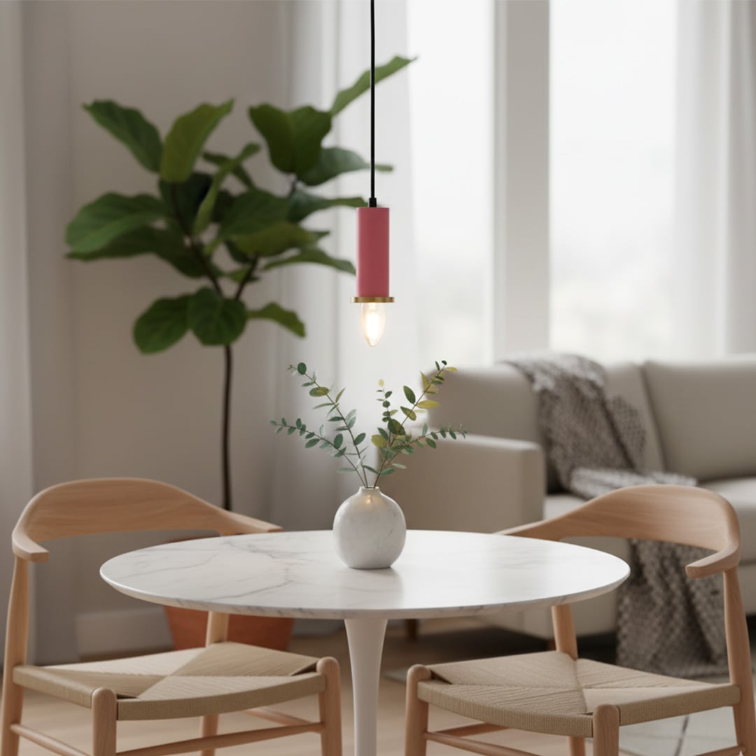 Pink metal pendant light hanging above a round dining table creating warm ambient lighting in a modern living and dining area.