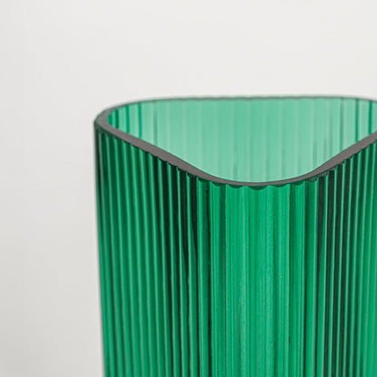 Close up view green ribbed glass vase showing vertical texture glossy finish luxury decorative glass accent for shelf styling home.
