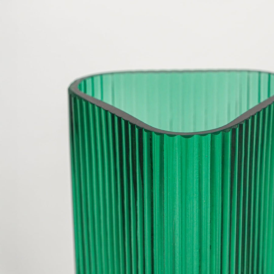 Close up view green ribbed glass vase showing vertical texture glossy finish luxury decorative glass accent for shelf styling home.
