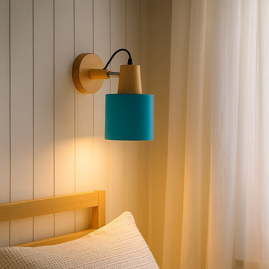 Wall mounted bedside wall light with turquoise shade and wooden base casting a soft warm glow beside a wooden bed creating a calm cozy bedroom ambiance.