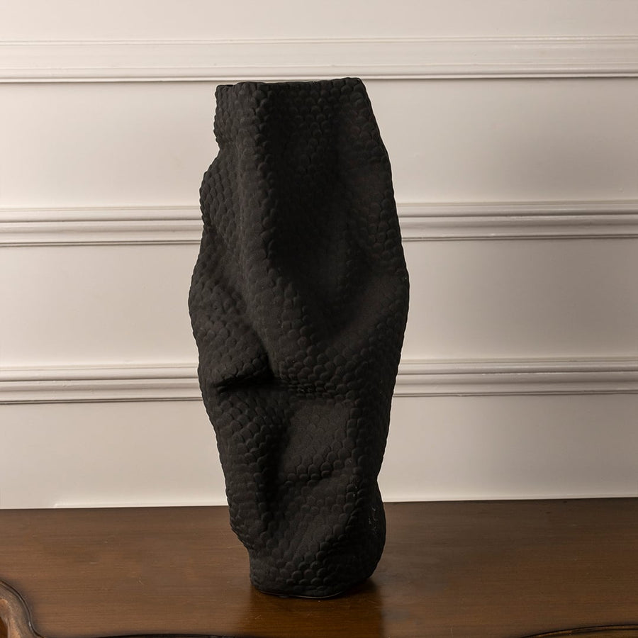 Handcrafted black ceramic vase with unique wavy design and matte finish on white background showcasing artistic detailing.