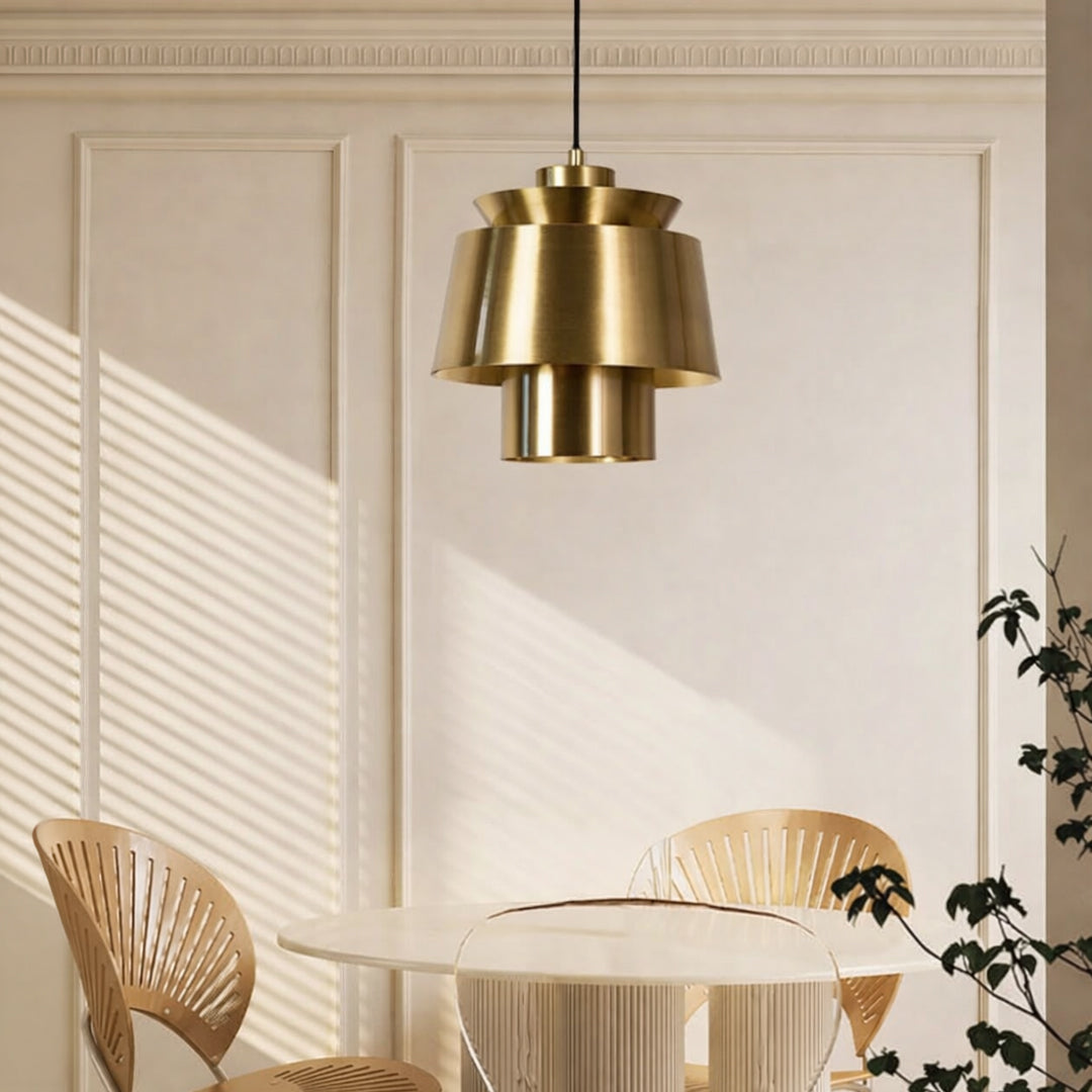 Brass metal pendant light above dining table adding modern luxury and warm ambient lighting to elegant interiors.