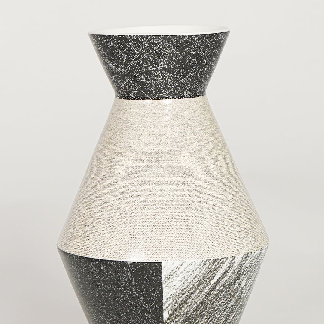 Closeup of black and white glazed ceramic vase with detailed textured finish ideal for shelf or side table decor styling.