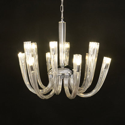 Modern chrome and clear glass chandelier glowing warmly on black background creating a striking modern ceiling feature.