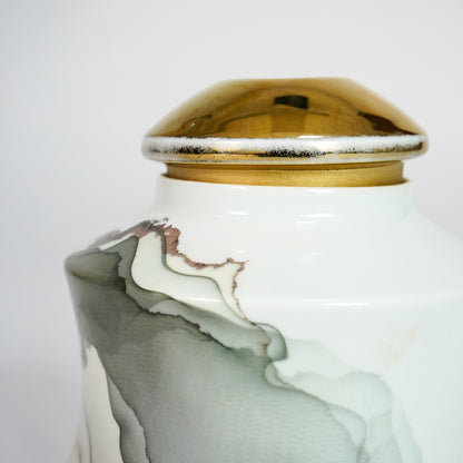 Closeup of white marble ceramic decorative jar with gold lid showcasing premium craftsmanship and elegant marble detailing.
