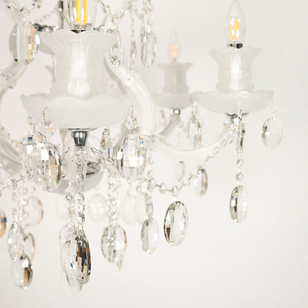 Closeup image of gold metal candle style chandelier for modern dining room decor styling with elegant crystal detailings.