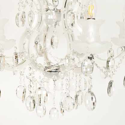 Closeup image of gold metal candle style chandelier for elegant living room decor styling with beautiful crystal accents.