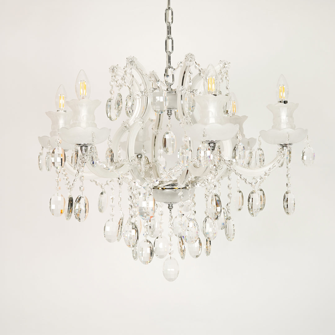 White background image of gold metal candle style chandelier for elegant dining room decor styling with unlit crystal arms.