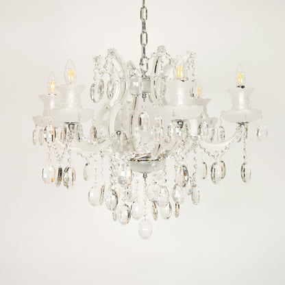White background image of gold metal candle style chandelier for elegant dining room decor styling with unlit crystal arms.