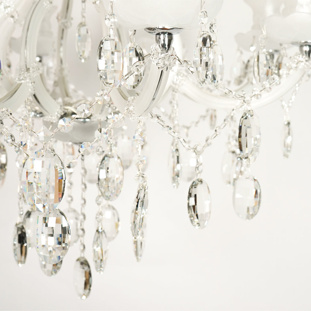 Closeup image of large gold metal candle style chandelier for modern dining room decor styling with elegant crystal detailings.