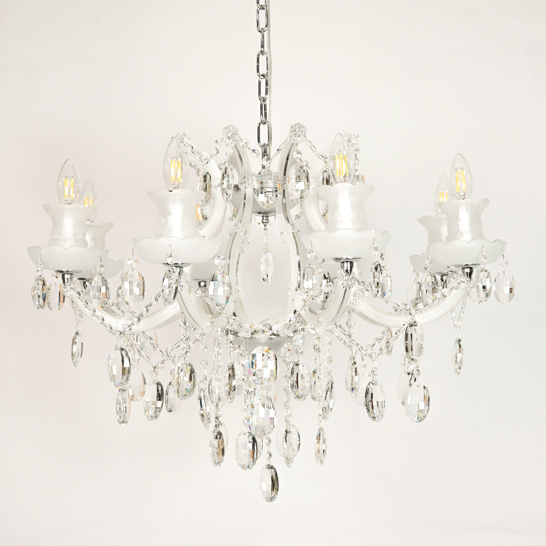 White background image of large gold metal candle style chandelier for elegant dining room decor styling with unlit crystal arms.