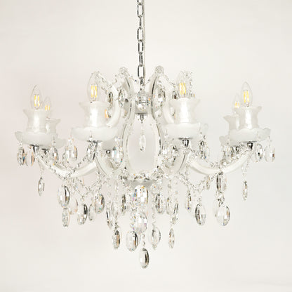 White background image of large gold metal candle style chandelier for elegant dining room decor styling with unlit crystal arms.