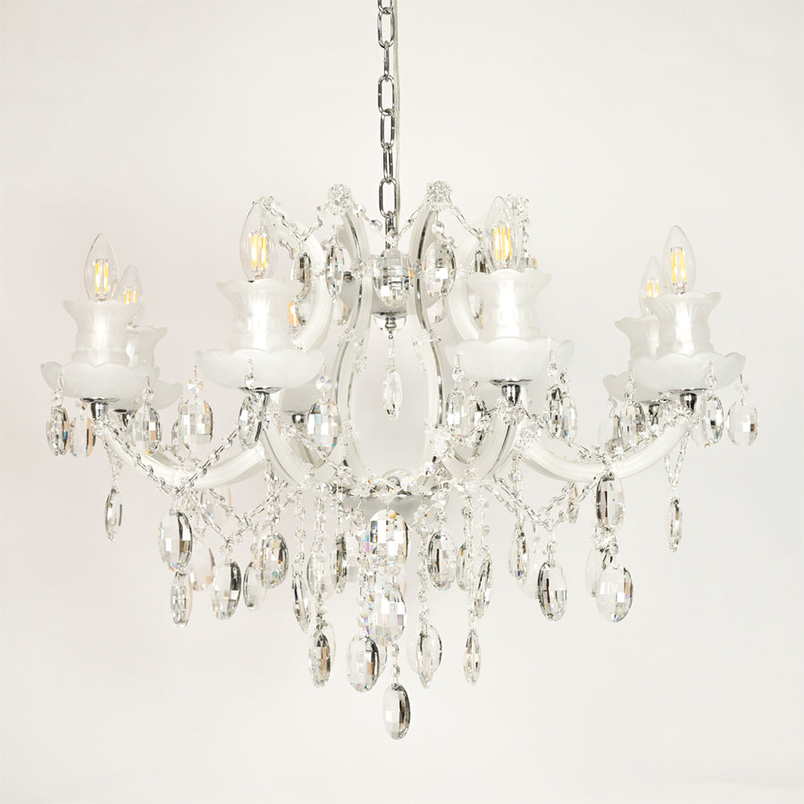 White background image of large gold metal candle style chandelier for elegant dining room decor styling with unlit crystal arms.