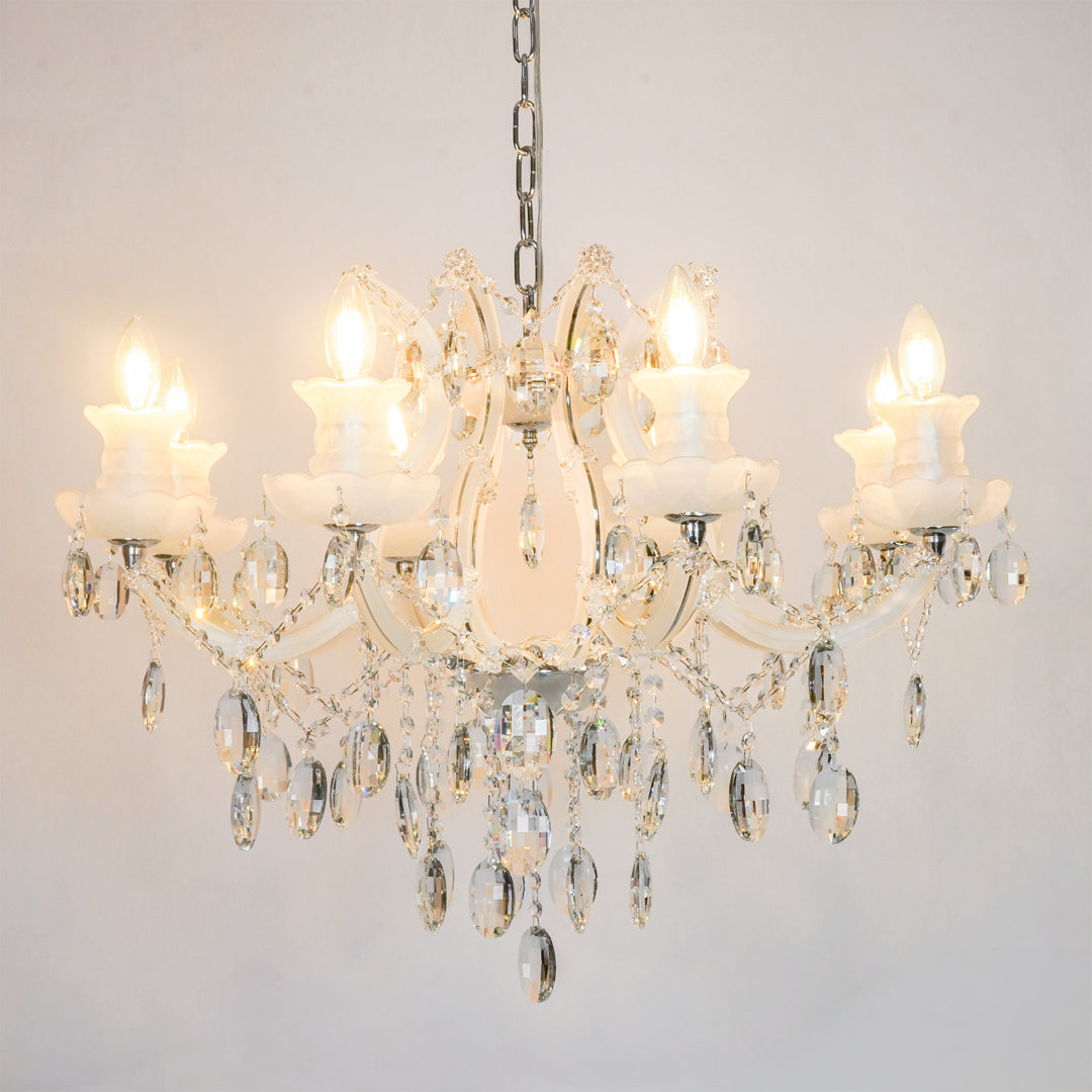 White background image of large gold metal candle style chandelier for modern living room decor styling with a bright warm glow.