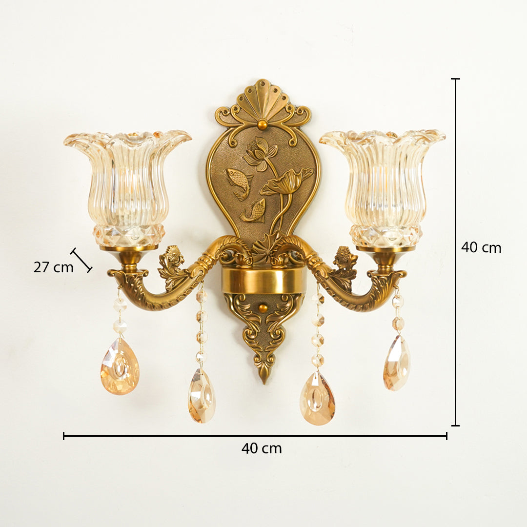 An ornate two-light wall sconce with a gold-toned metal frame, clear ribbed glass shades, and hanging crystal teardrop drops, shown with dimension labels indicating 40 cm width, 40 cm height, and 27 cm shade-to-center spacing on a white background.