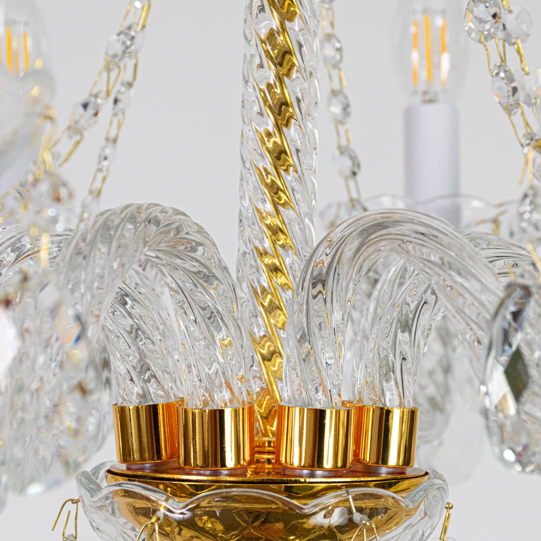Closeup of gold metal crystal chandelier with detailed crystal drops perfect for luxury interior ceiling decor.