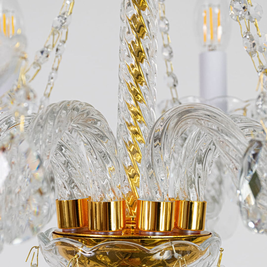 Closeup of gold metal crystal chandelier with detailed crystal drops perfect for luxury interior ceiling decor.