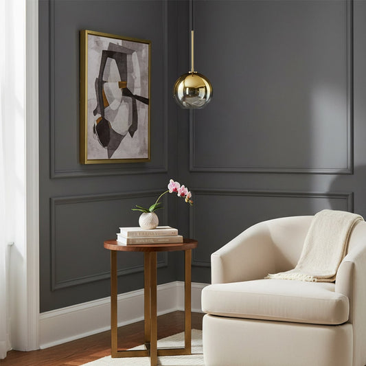Lifestyle image of a gold glass pendant light switched on above a side table in a modern living room creating a warm ambient glow with elegant Decor styling.