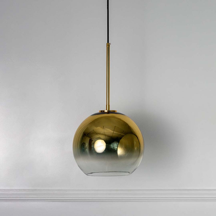 Golden glass globe pendant light with sleek rod detail elegant modern ceiling lamp for dining room bedroom and stylish interiors.