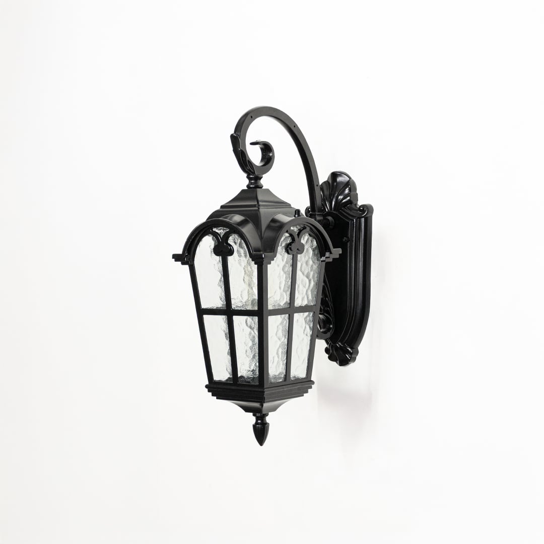 Outdoor wall lantern in black metal with textured glass switched off on white background highlighting classic lantern design.