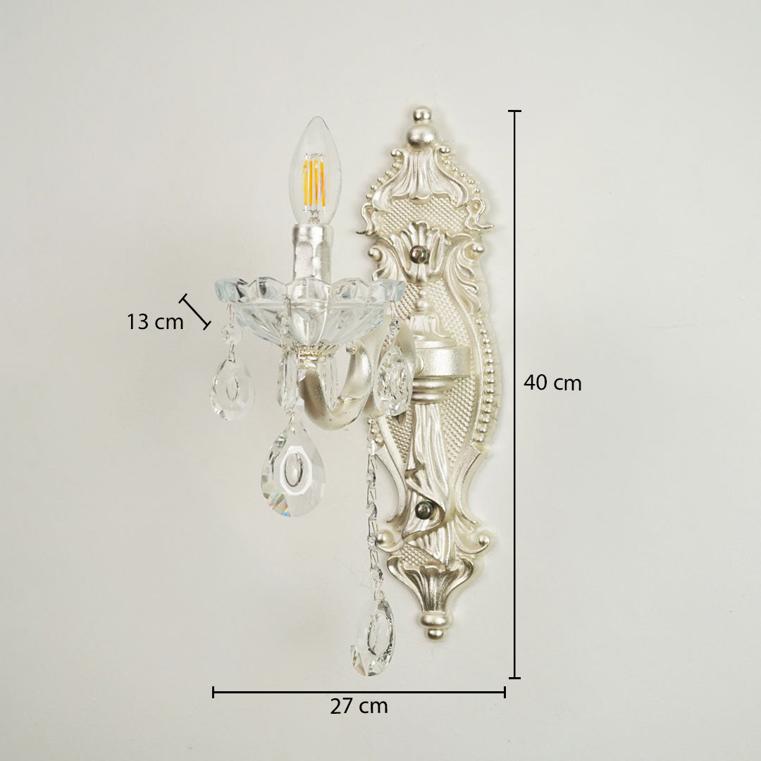 Silver wall sconce with clear glass crystal teardrop pendants, shown with dimension markings of 27 cm width, 40 cm height, and 13 cm arm depth against a plain light background.