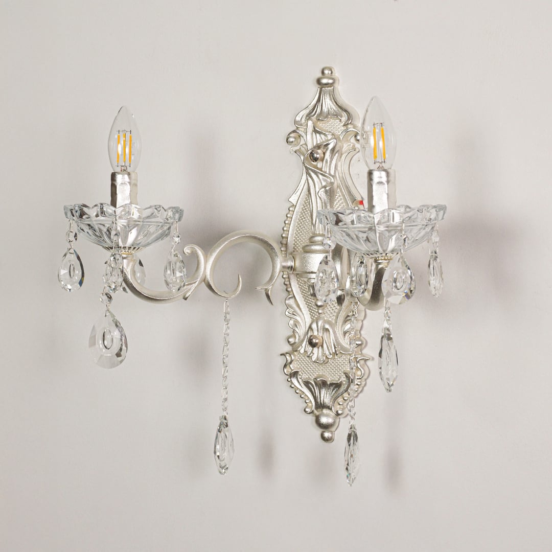Wall light with silver metal frame and crystal accents displayed on a white background for clear refined product viewing.