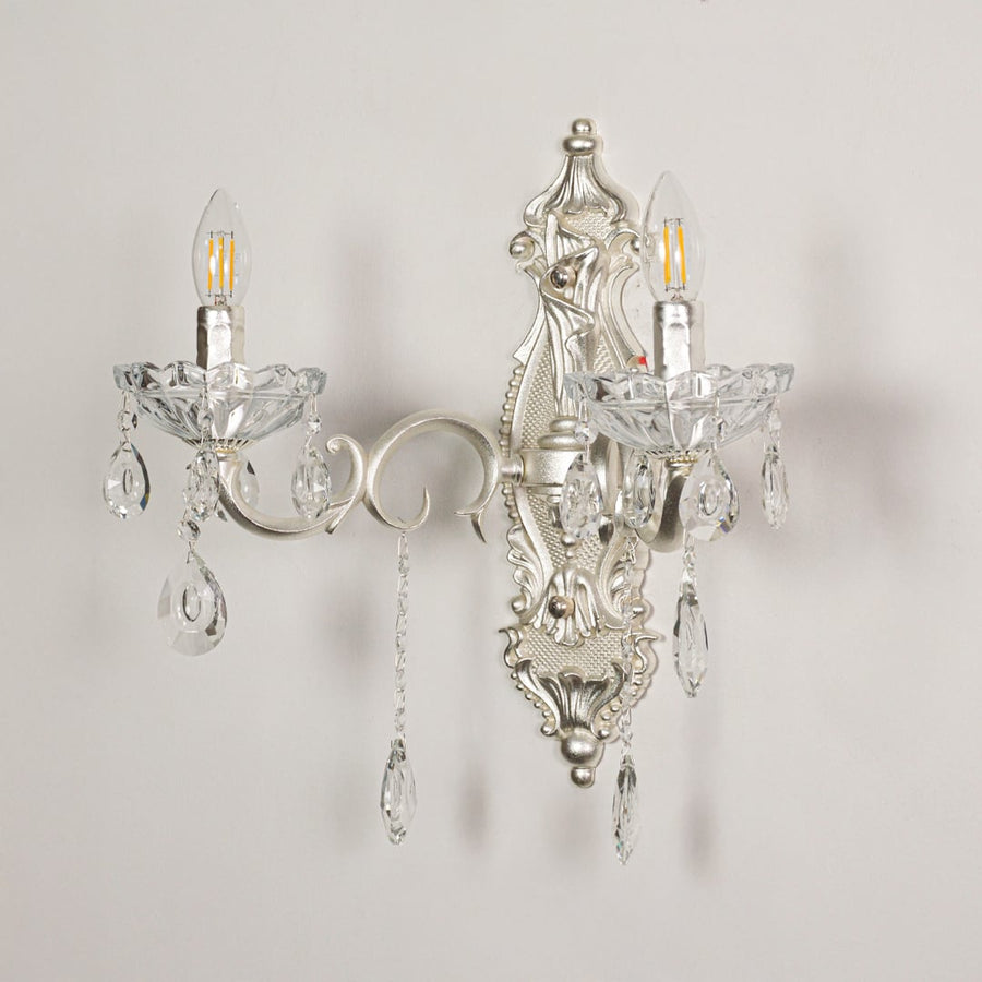 Wall light with silver metal frame and crystal accents displayed on a white background for clear refined product viewing.