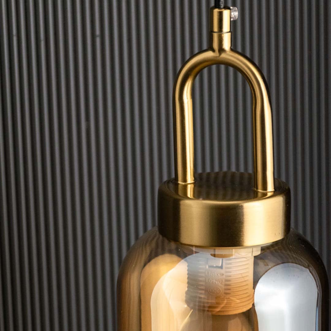 A detailed closeup of the amber glass pendant light highlighting the smooth curved glass surface and gold loop accent suited for elegant decor.