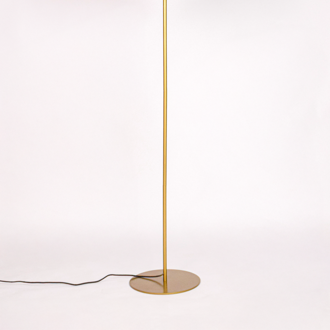 White background image of gold metal floor lamp base for elegant living room decor styling and modern home lighting design.