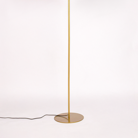 White background image of gold metal floor lamp base for elegant living room decor styling and modern home lighting design.