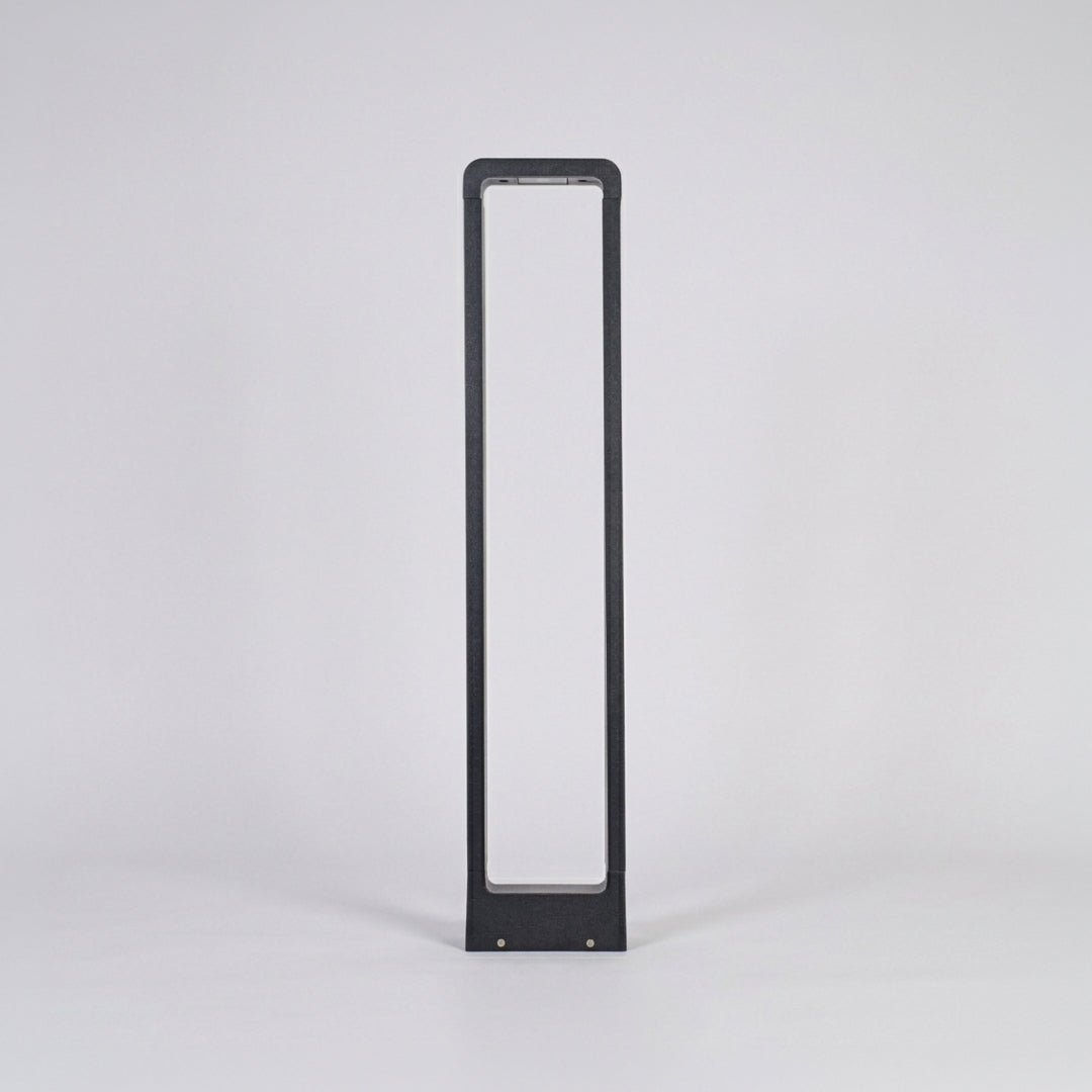 Contemporary outdoor bollard light with slim black frame and frosted panel on neutral background ideal for modern garden or driveway lighting.