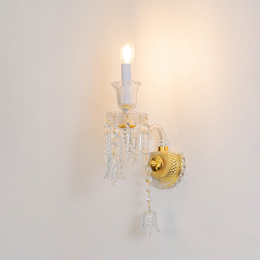 Classic crystal wall light in gold finish with single candle bulb for bedroom or living decor lighting white background.