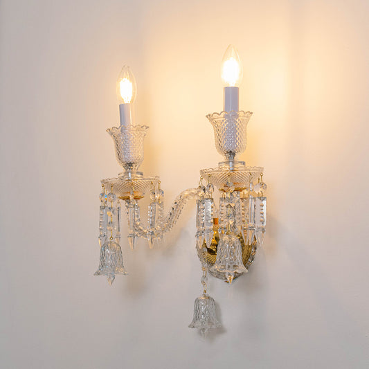 Elegant crystal wall light in gold finish with candle bulbs for bedroom or living room decor lighting white background.