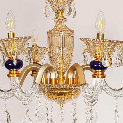 Closeup of gold and clear crystal chandelier with navy accents and crystal drops perfect for luxury ceiling decor.