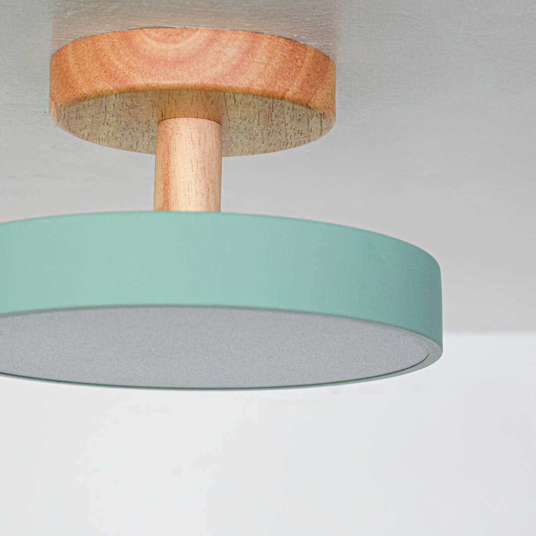 Closeup of mint green metal and natural wood ceiling light for Scandinavian interior and modern decor styling spaces.