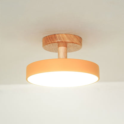 Closeup of peach metal and natural wood ceiling light for contemporary bedroom and Scandinavian decor styling spaces.