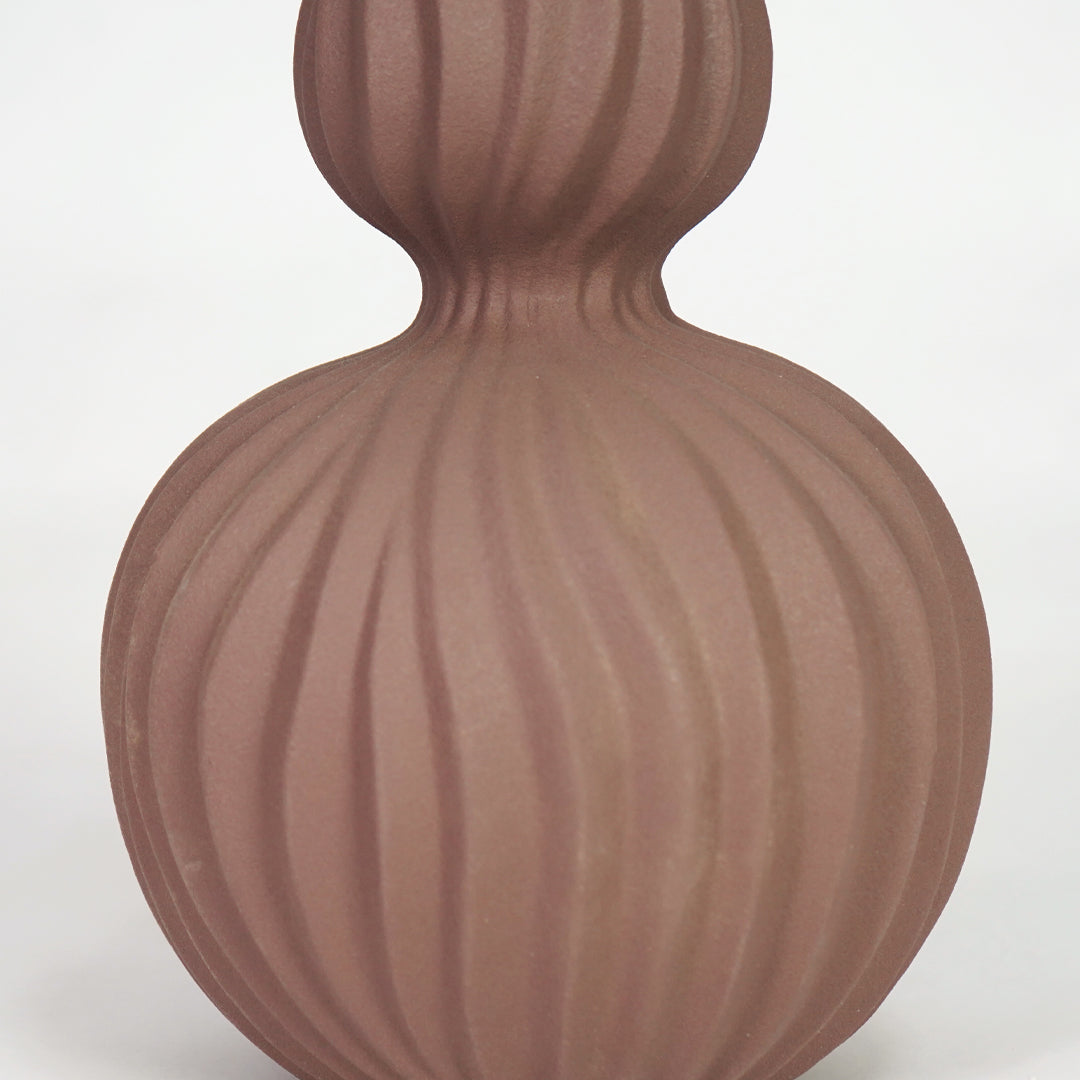 Closeup image of brown ceramic fluted vase for modern living room table decor with elegant matte finish styling.