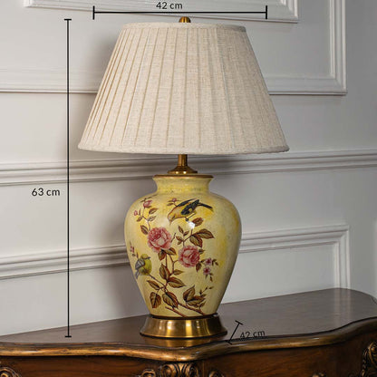 Yellow ceramic table lamp with floral design showing 63 cm height and 42 cm width for detailed product dimensions.